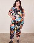 Ashley is 5'7" and wearing 1XL Petite Petite Short Sleeve Jumpsuit in Rainbow Magic Waters