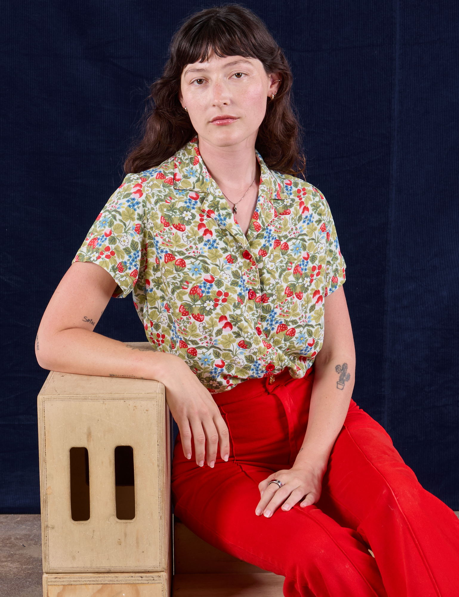 Alex is wearing Off-White Strawberry Pantry Button-Up paired with mustang red Western Pants