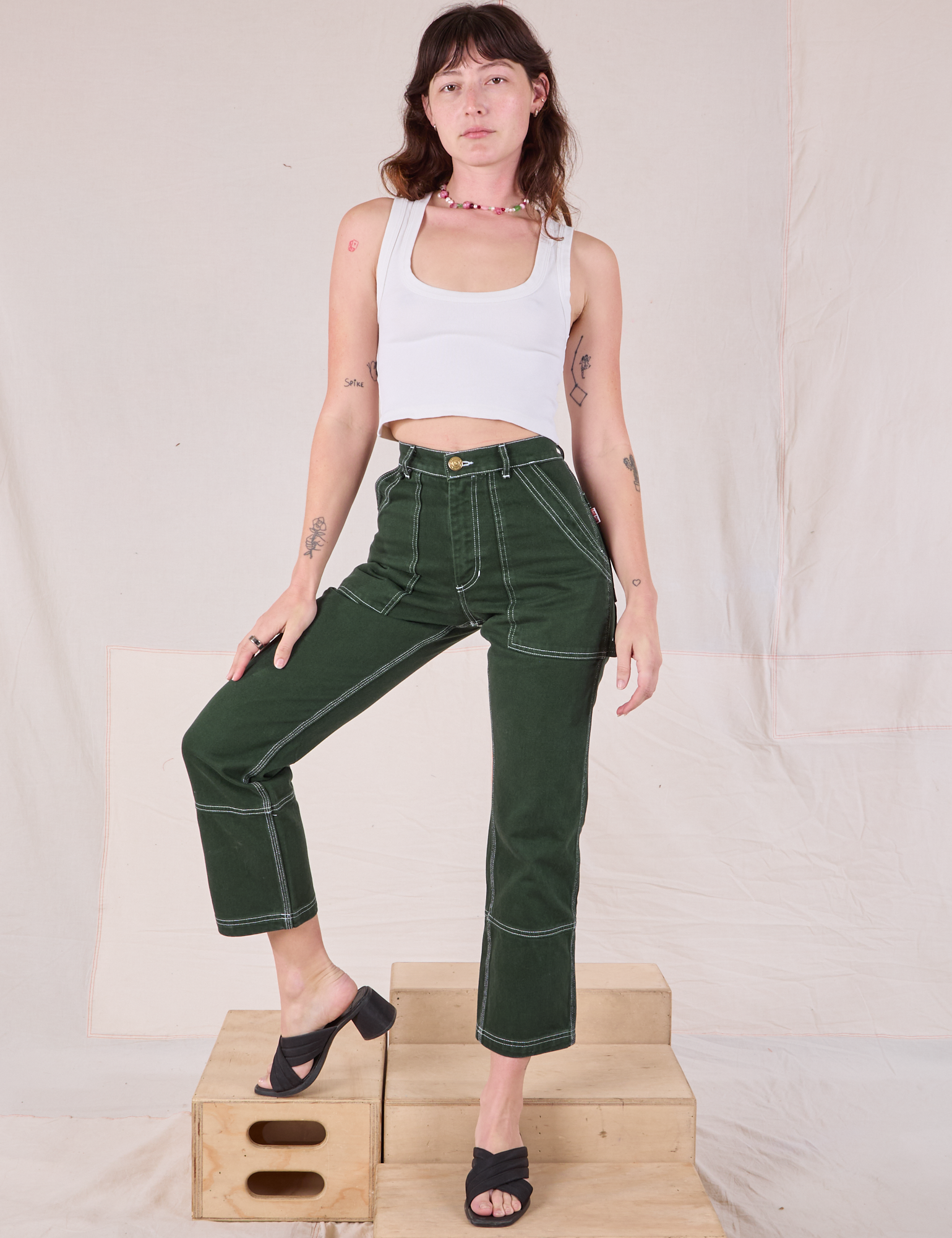 Alex is wearing Carpenter Jeans in Swamp Green and Cropped Tank in Vintage Tee Off-White