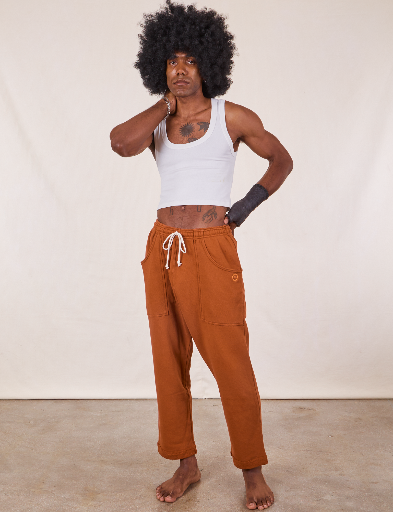 Jerrod is 6&#39;3&quot; and wearing M Cropped Rolled Cuff Sweatpants in Burnt Terracotta paired with vintage off-white Cropped Tank Top