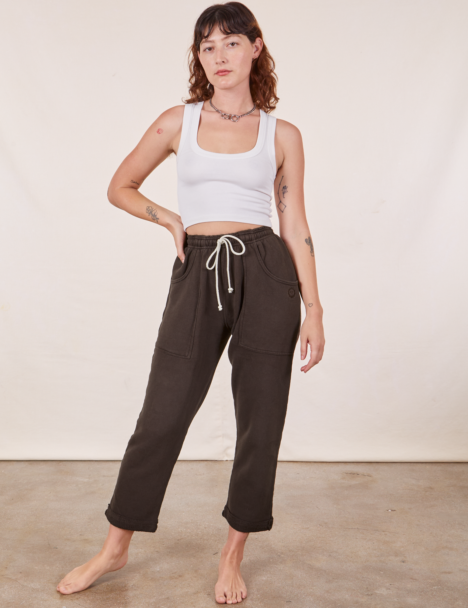 Alex is 5&#39;8&quot; and wearing XXS Cropped Rolled Cuff Sweatpants in Espresso Brown paired with vintage off-white Cropped Tank Top