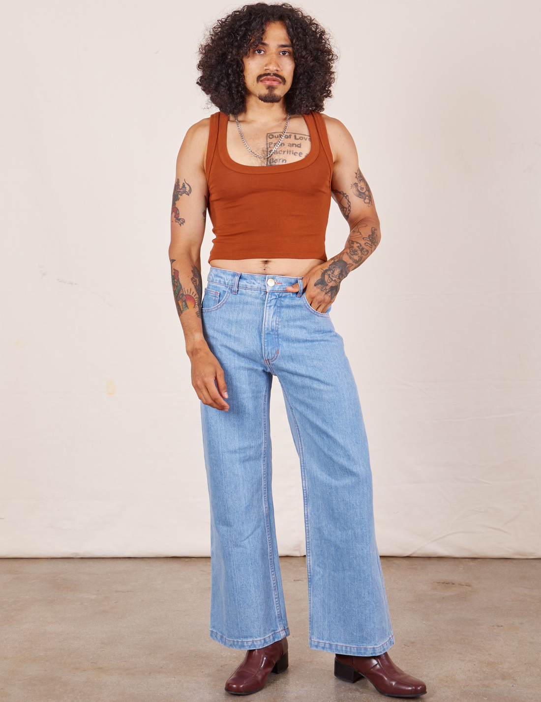 Jesse is wearing Cropped Tank Top in Burnt Terracotta paired with light washed Sailor Jeans