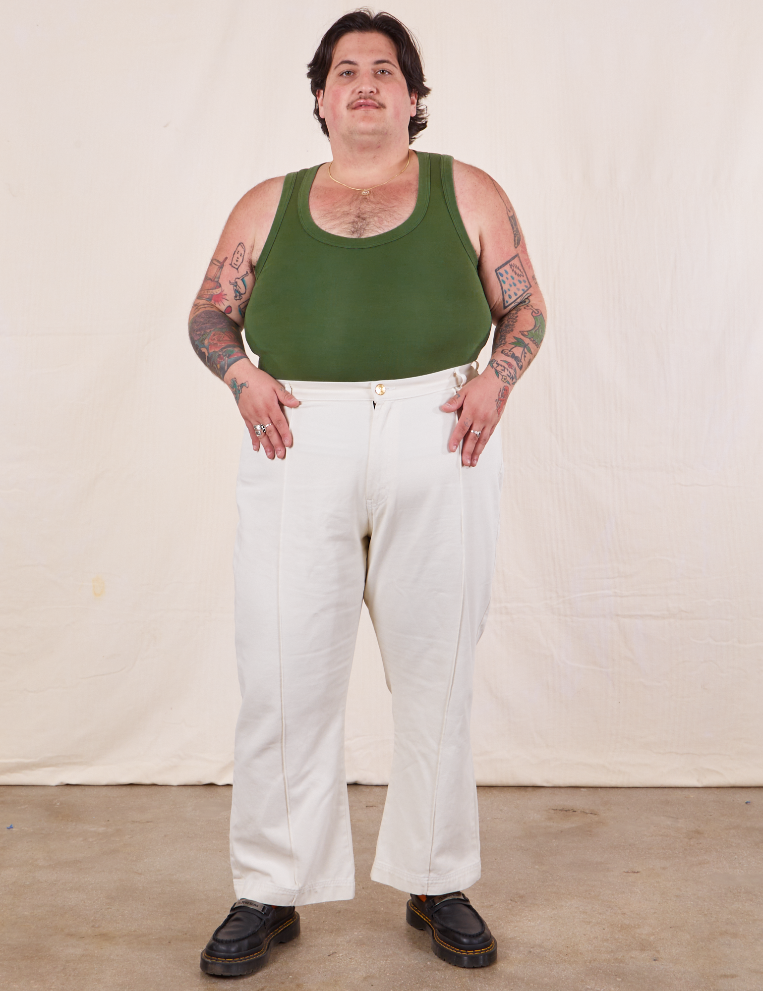 Sam is wearing Tank Top in Dark Emerald Green and vintage off-white Western Pants