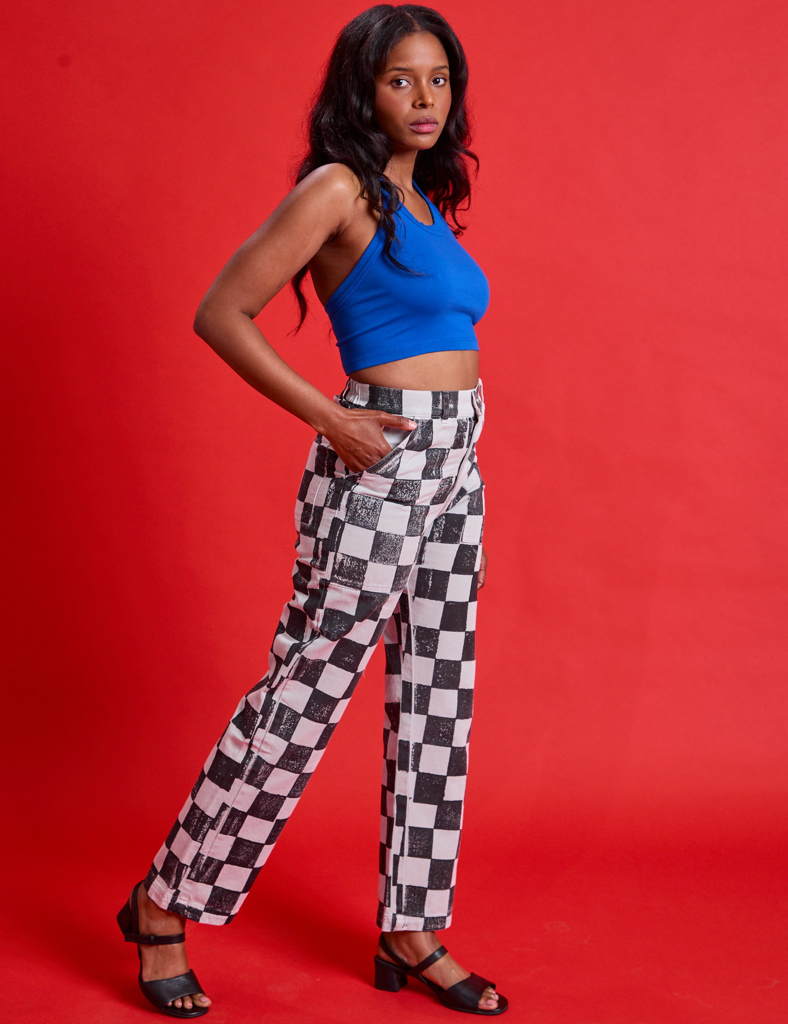 Side view of Checkerboard Work Pants in Black/White and royal blue Halter Top