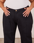 Front close up of Western Pants in Basic Black. Alicia has her thumbs in both belt loops.