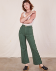 Alex is wearing Western Pants in Dark Green Emerald and vintage off-white Tank Top