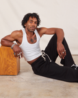 Jerrod is wearing Wide Leg Sweat Pants in Basic Black and Cropped Tank in vintage tee off-white