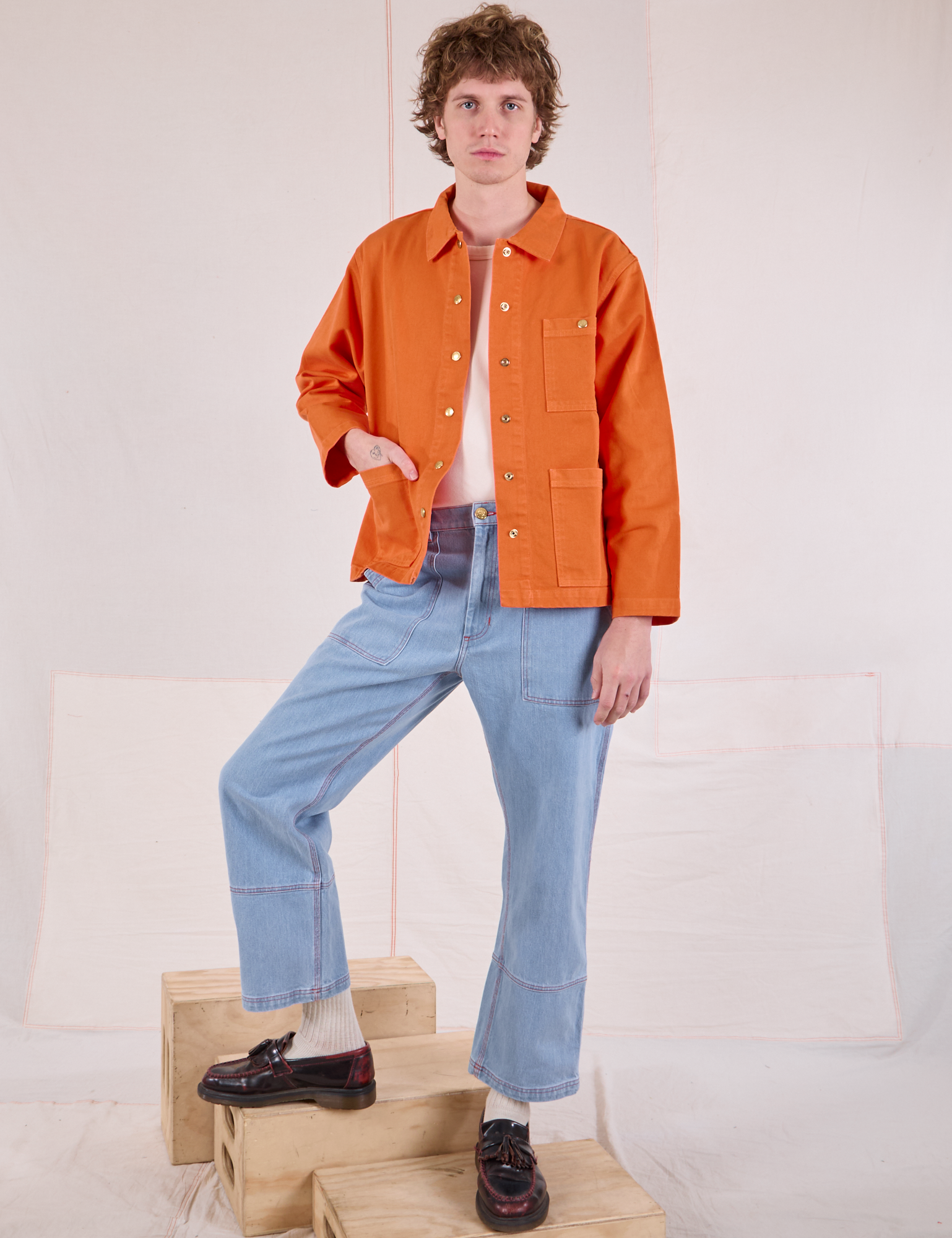 Quinn is wearing Denim Work Jacket in Construction Orange and light wash Carpenter Jeans