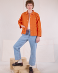 Quinn is wearing Denim Work Jacket in Construction Orange and light wash Carpenter Jeans