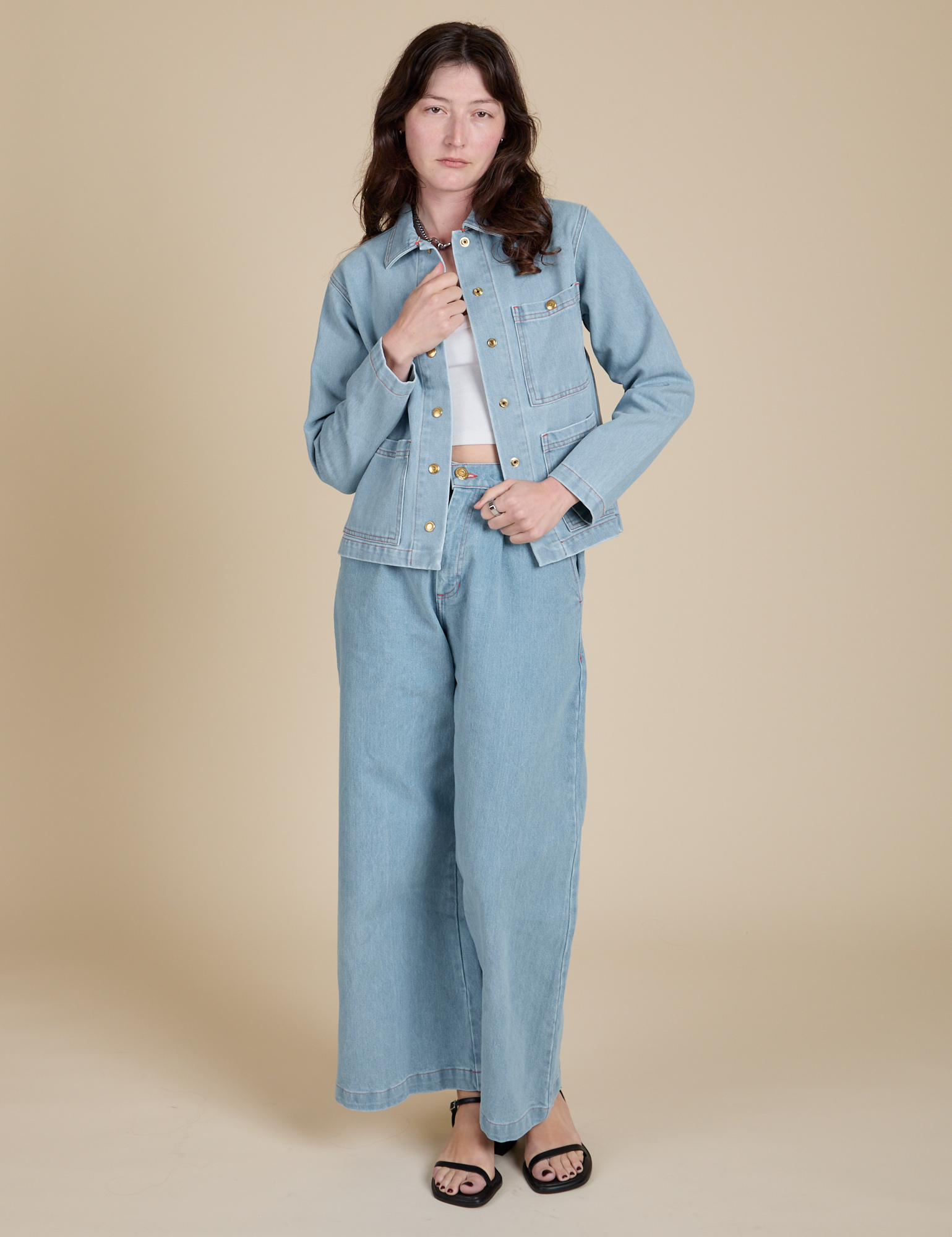Alex is wearing Indigo Denim Work Jacket in Light Wash paired with light wash Indigo Wide Leg Trousers