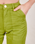 Work Pants in Gross Green front pocket close up. Alex has her hand in the pocket.