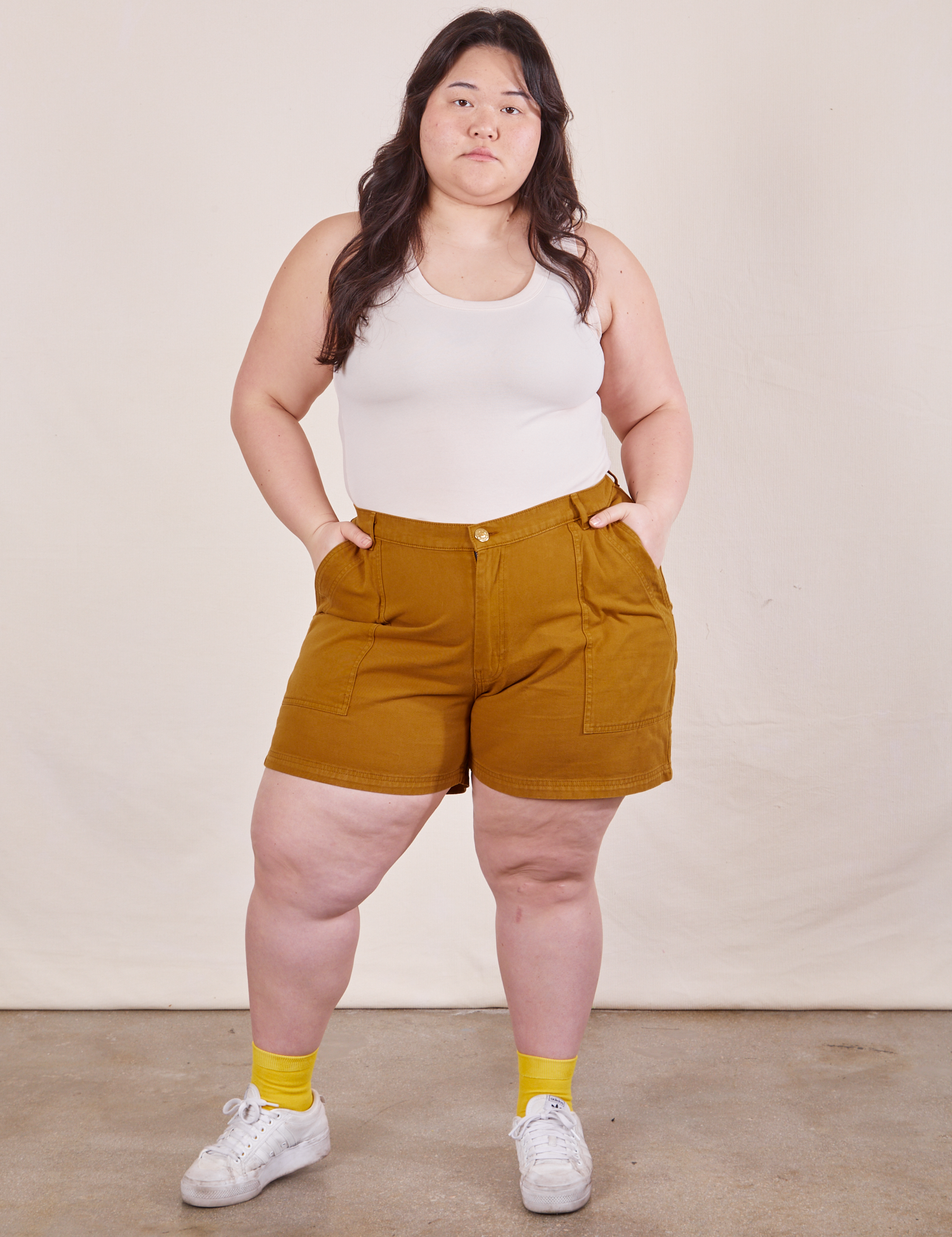 Ashley is wearing Classic Work Shorts in Spicy Mustard and a Tank Top in vintage tee off-white