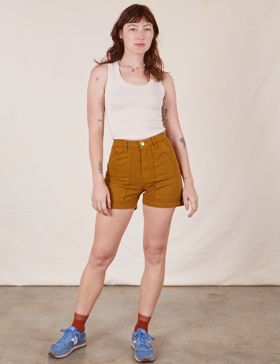 Alex is wearing Classic Work Shorts in Spicy Mustard and vintage off-white Tank Top