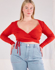 Lish is wearing Wrap Top in Mustang Red and light wash Carpenter Jeans