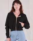 Alex is 5'8" and wearing P Cropped Zip Hoodie in Basic Black paired with light wash Carpenter Jeans