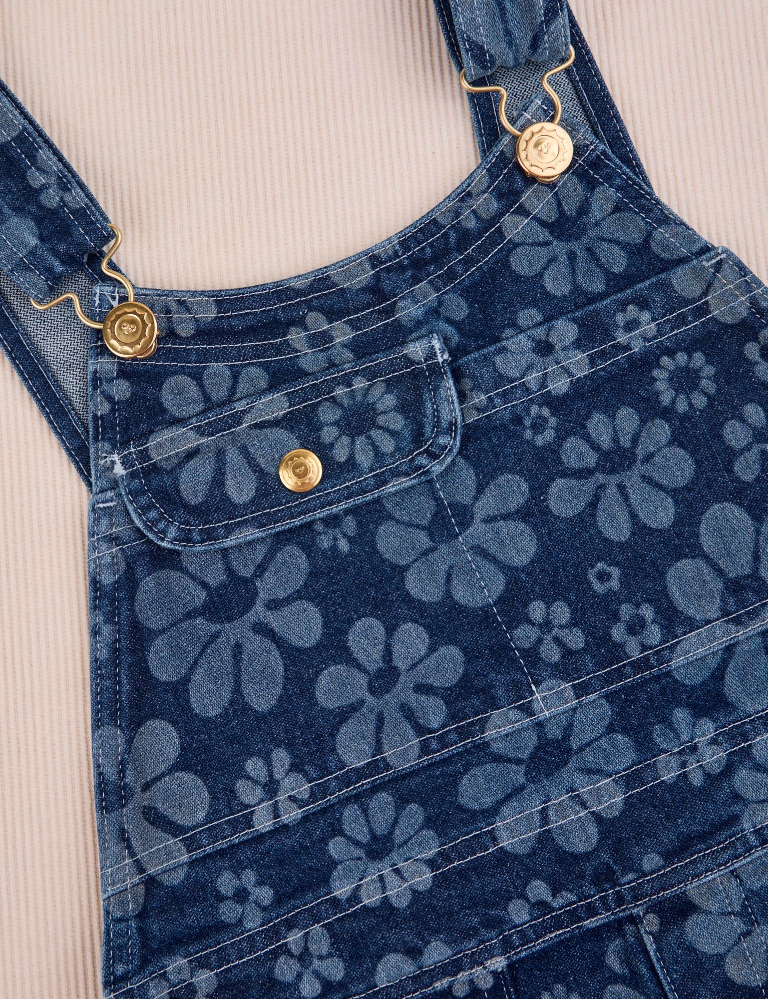Carpenter Overalls in Lazy Daisy front close up. White top stitching and brass details.