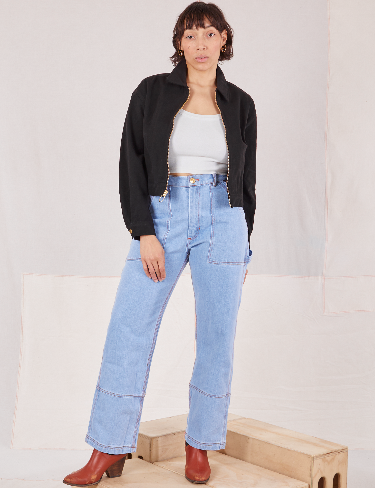 Tiara is wearing Ricky Jacket in Basic Black with a vintage tee off-white Cropped Tank Top and light wash Carpenter Jeans