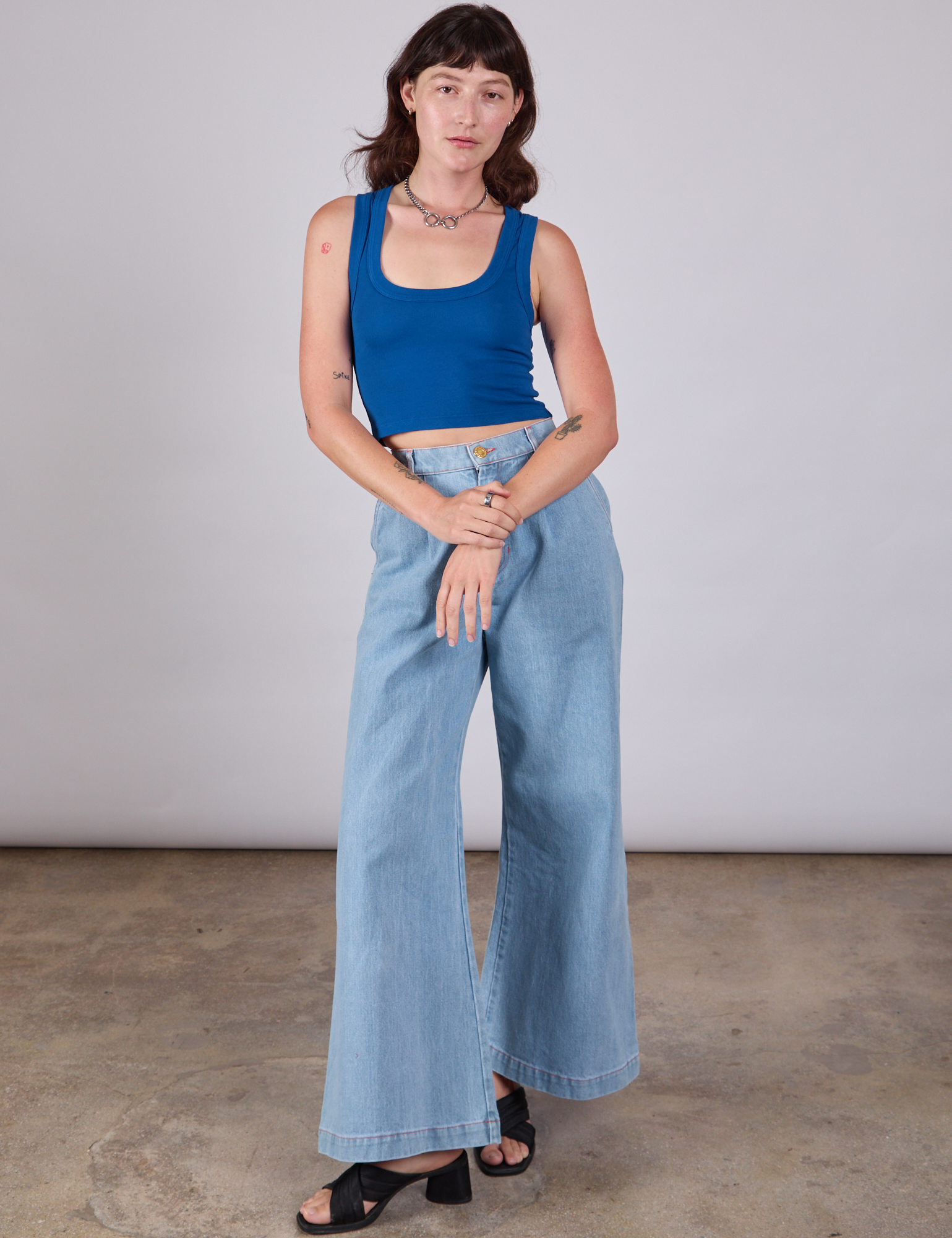 Alex is wearing Cropped Tank Top in Royal Blue and light wash Indigo Wide Leg Trousers