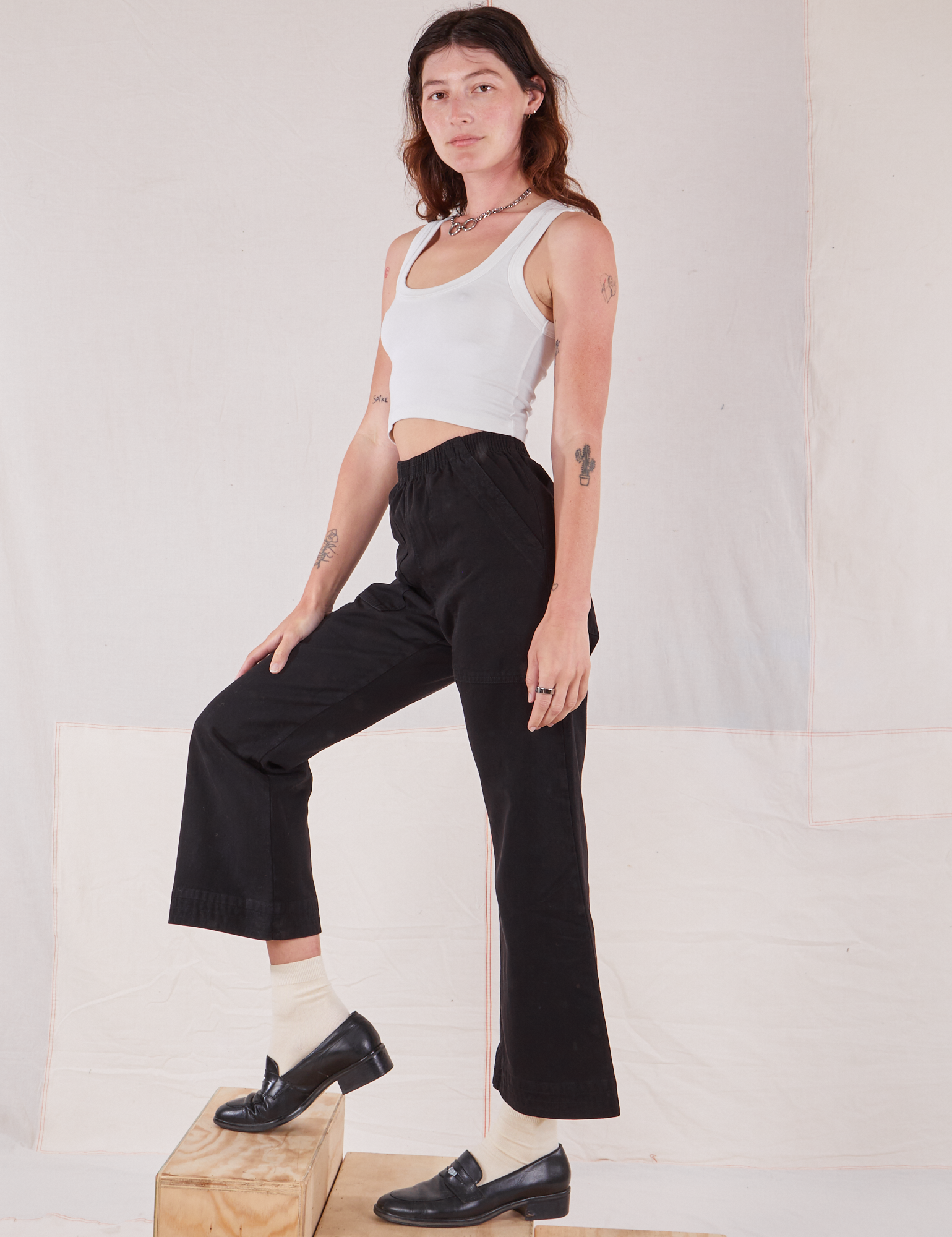 Side view of Action Pants in Basic Black and Cropped Tank in vintage tee off-white on Alex