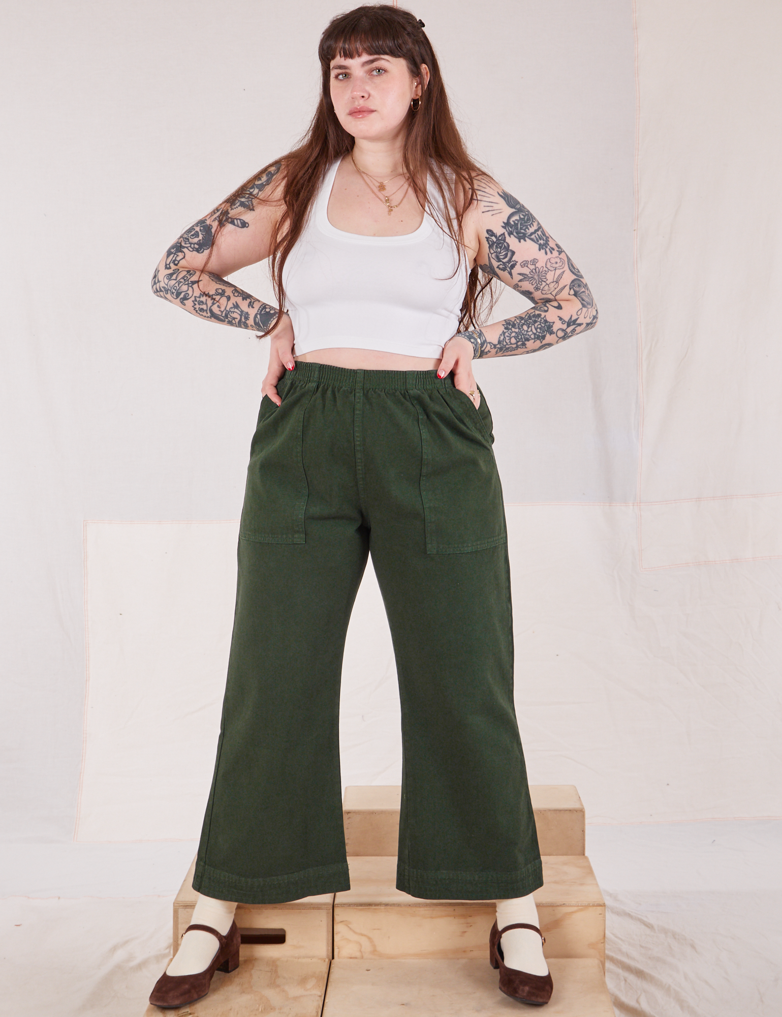 Sydney is wearing Action Pants in Swamp Green and Cropped Tank in vintage tee off-white