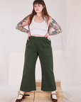 Sydney is wearing Action Pants in Swamp Green and Cropped Tank in vintage tee off-white