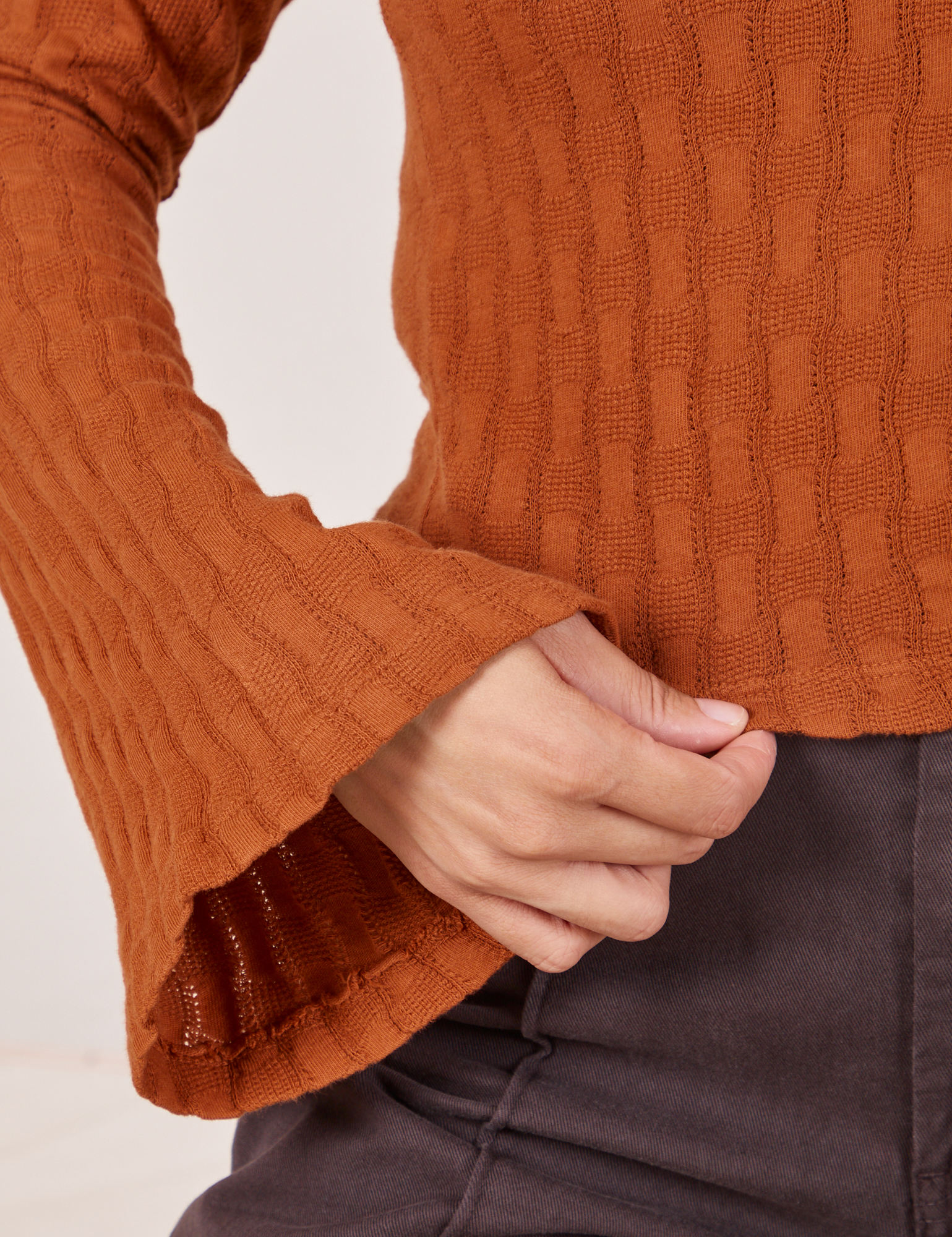 Sleeve and hem close up of Bell Sleeve Top in Burnt Terracotta worn by Tiara