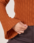 Sleeve and hem close up of Bell Sleeve Top in Burnt Terracotta worn by Tiara