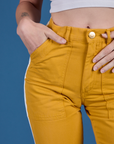 Close up of Alex's hand in the front pocket of Painted Work Pants in Mustard Yellow