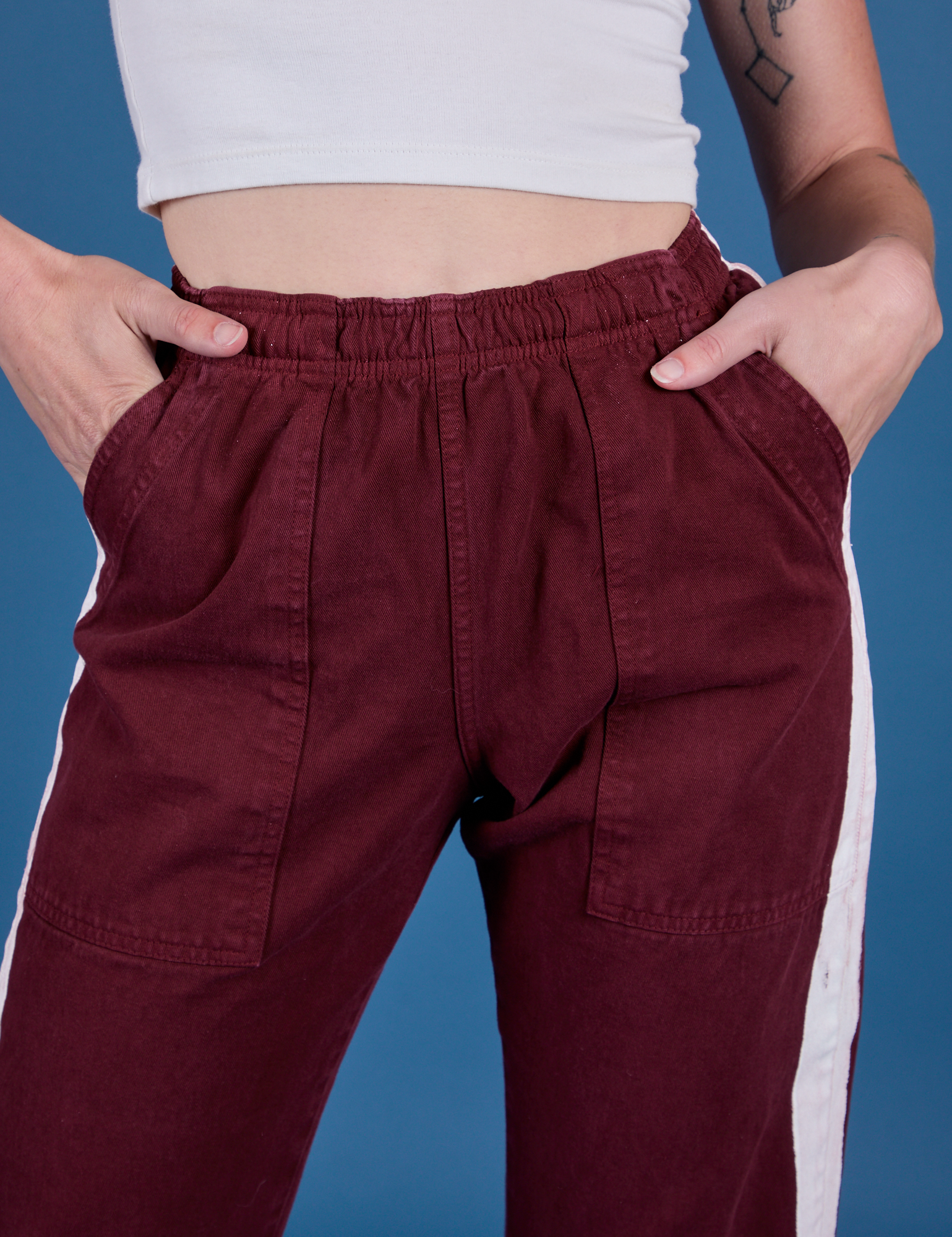 Painted Action Pants in Red Wine front close up with Alex's hand in both pockets