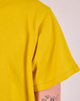 Burly Tee in Golden Yellow sleeve close up on Quinn