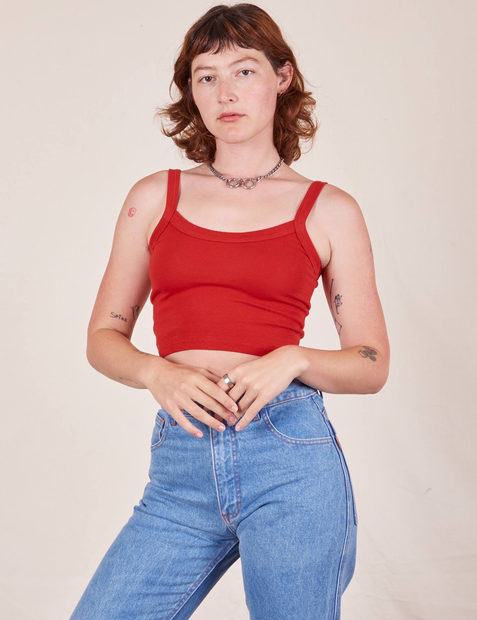 Alex is wearing Cropped Cami in Mustang Red and light wash Frontier Jeans