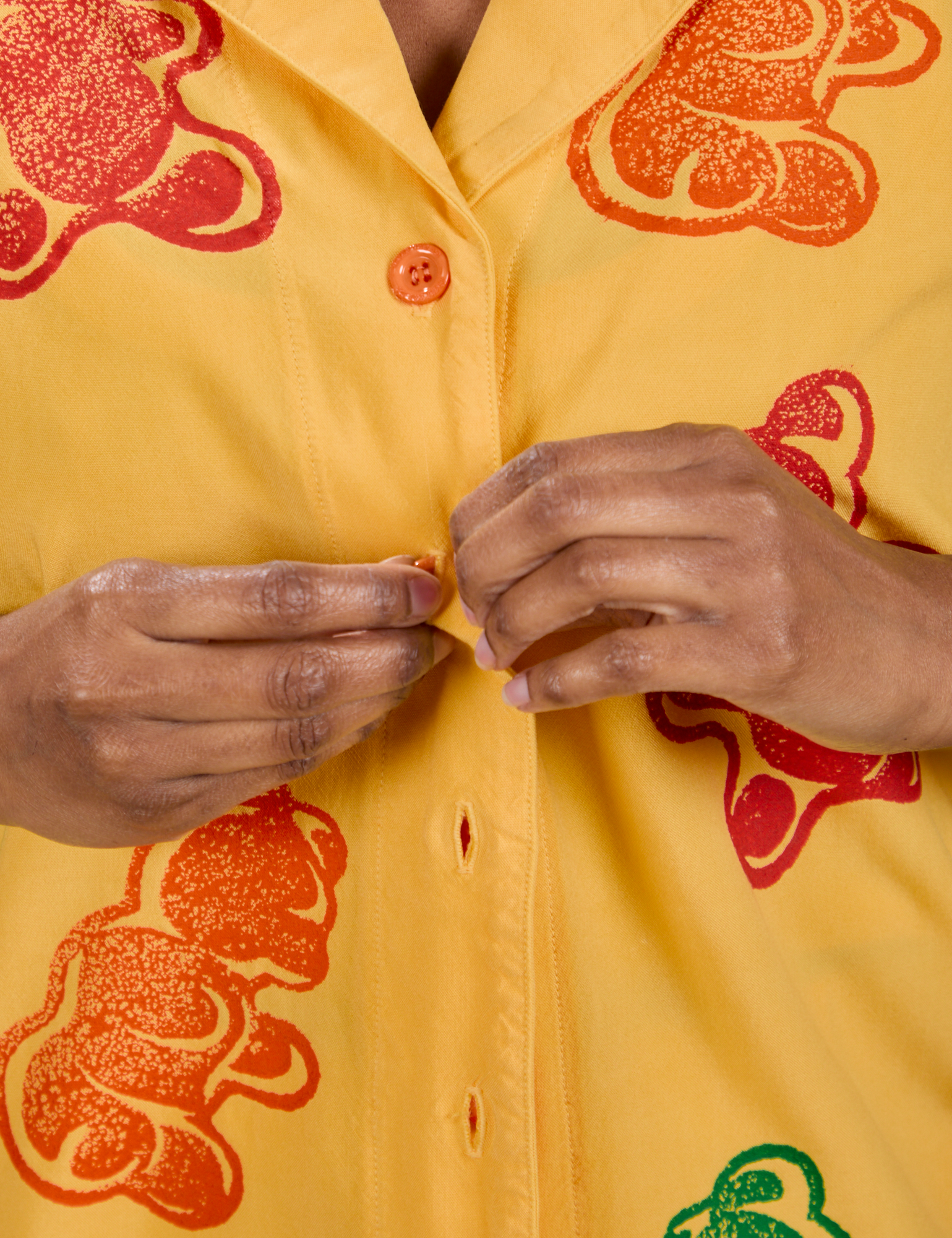 Close up of Kandia buttoning the Gummy Bear Pantry Button-Up 