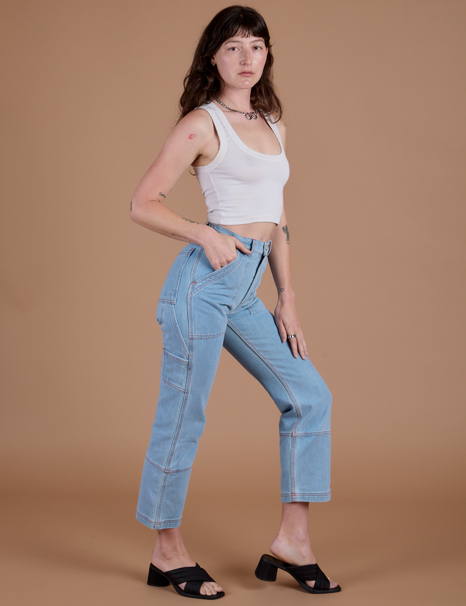 Side view of Carpenter Jeans in Light Wash and Cropped Tank in Vintage Tee White on Alex