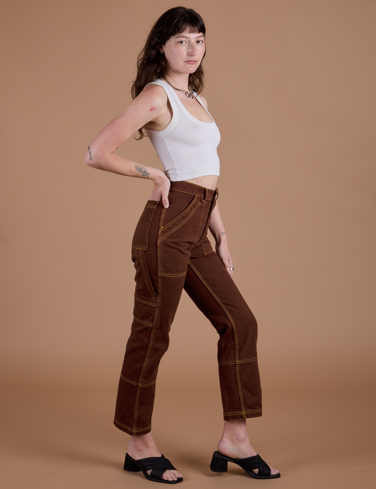 Side view of Carpenter Jeans in Fudgesicle Brown and Cropped Tank in Vintage Tee Off-White