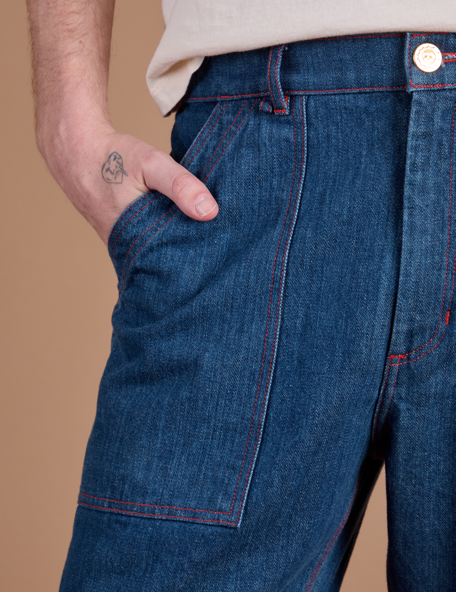 Close up of Quinn's hand in the front pocket of Carpenter Jeans in Dark Wash