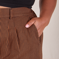 Front pocket close up Checker Trousers in Brown. Morgan has her hand in the pocket.