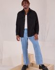 Isaac is waering Flannel Overshirt in Basic Black and light wash Carpenter Jeans