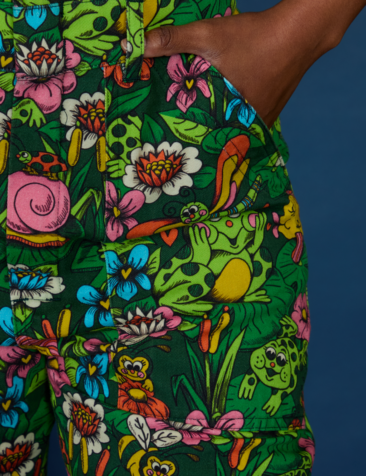 Close up of Kandia's hand in the front pocket of Pond Party Print Jumpsuit