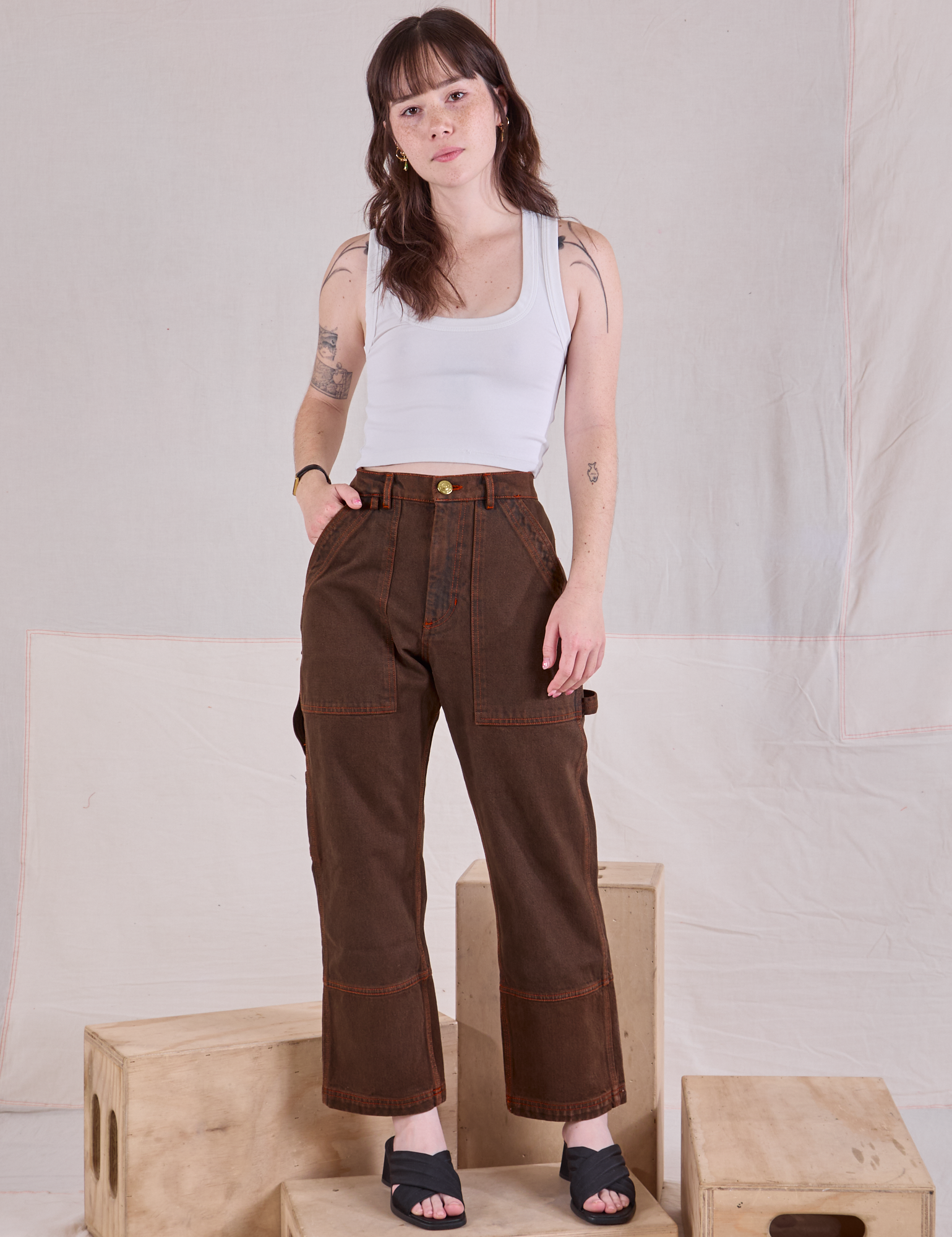 Hana is wearing Overdyed Carpenter Jeans in Fudge and Cropped Tank in vintage tee off-white