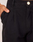 Front close up of Heavyweight Trousers in Basic Black. Jesse has their hand in the pocket. 