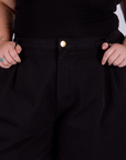 Pleated Trouser Shorts in Basic Black front close up with Juliet holding the belt loops