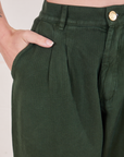 Heritage Trousers in Swamp Green front pocket close up. Alex has her hand in the pocket.
