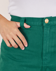 Front close up of Bell Bottoms in Hunter Green. Tiara has her thumb in the belt loop.