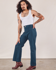 Angled front view of Western Pants in Lagoon and vintage tee off-white Cropped Tank on Jesse