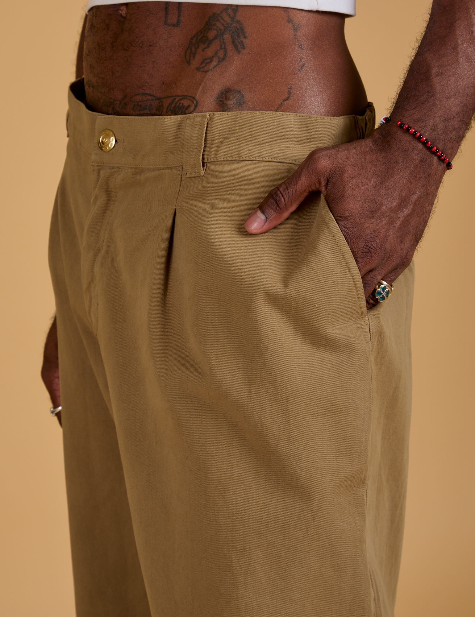 Close up of Jerrod&#39;s hand in the front pocket of Baggy Mid-Rise Trousers in Desert Brown
