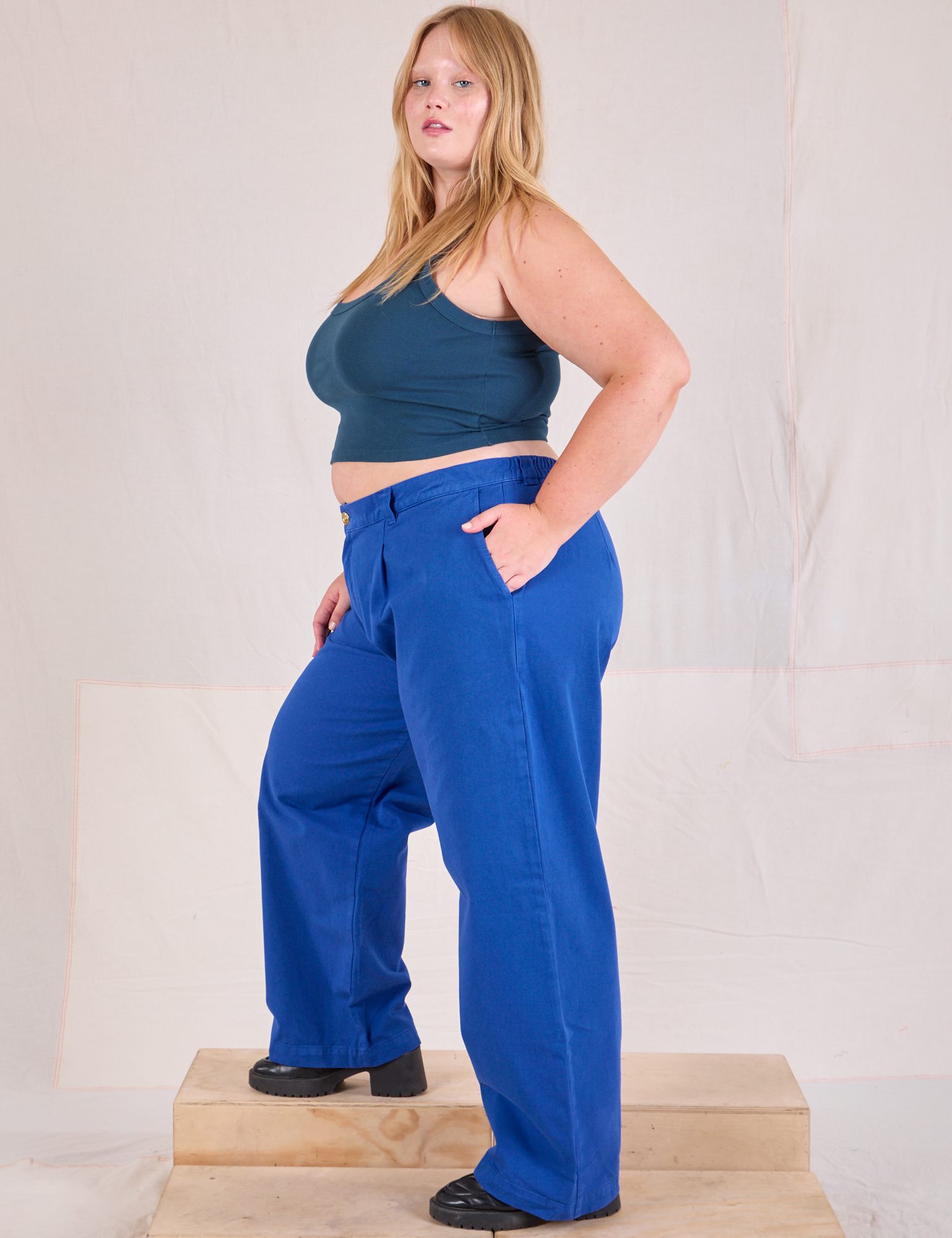 Side view of Mid-Rise Pleated Trousers in Royal Blue and lagoon Cropped Tank on Juliet