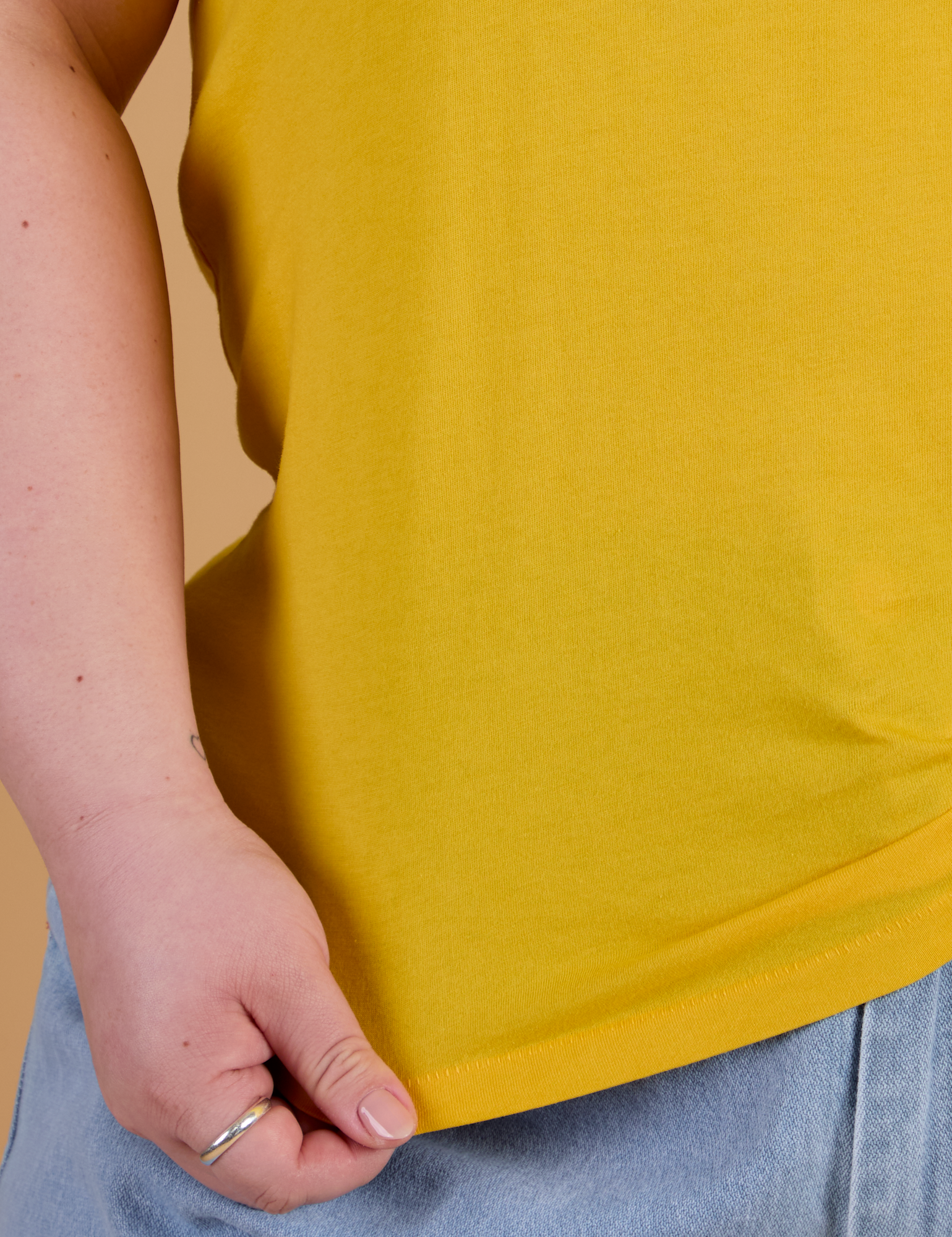 Organic Vintage Tee in Sunshine Yellow bottom close up with Ashley holding hem