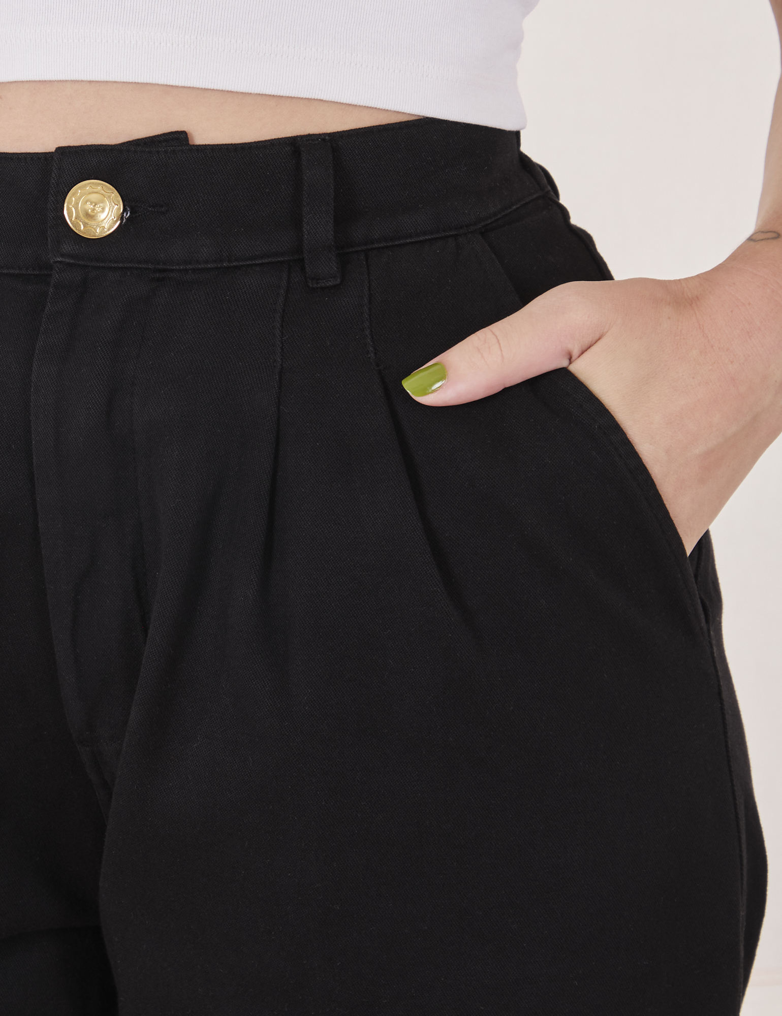 Front close up of Organic Trousers in Basic Black. Alex has her hand in the pocket.