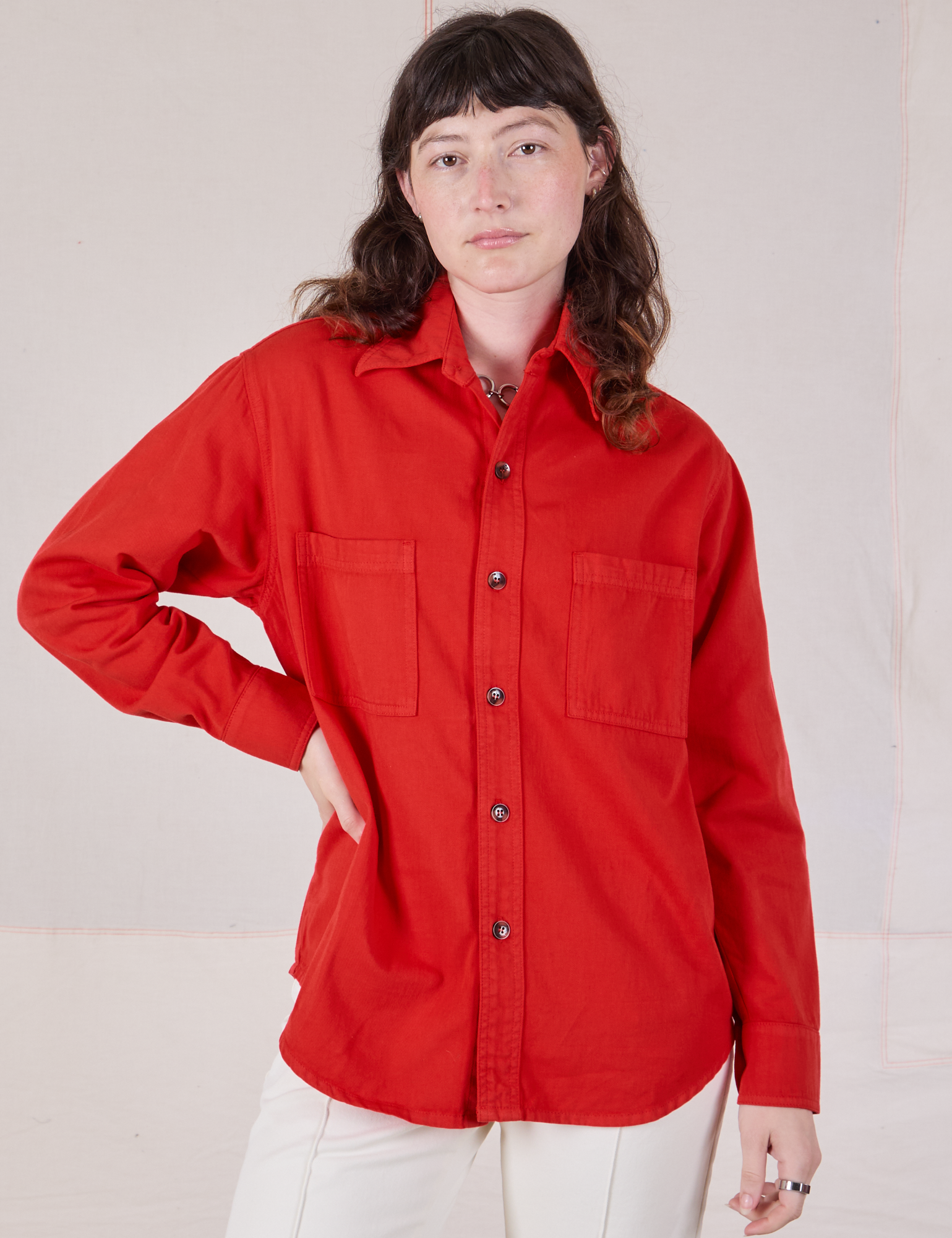 Alex is wearing a buttoned up Twill Overshirt in Mustang Red