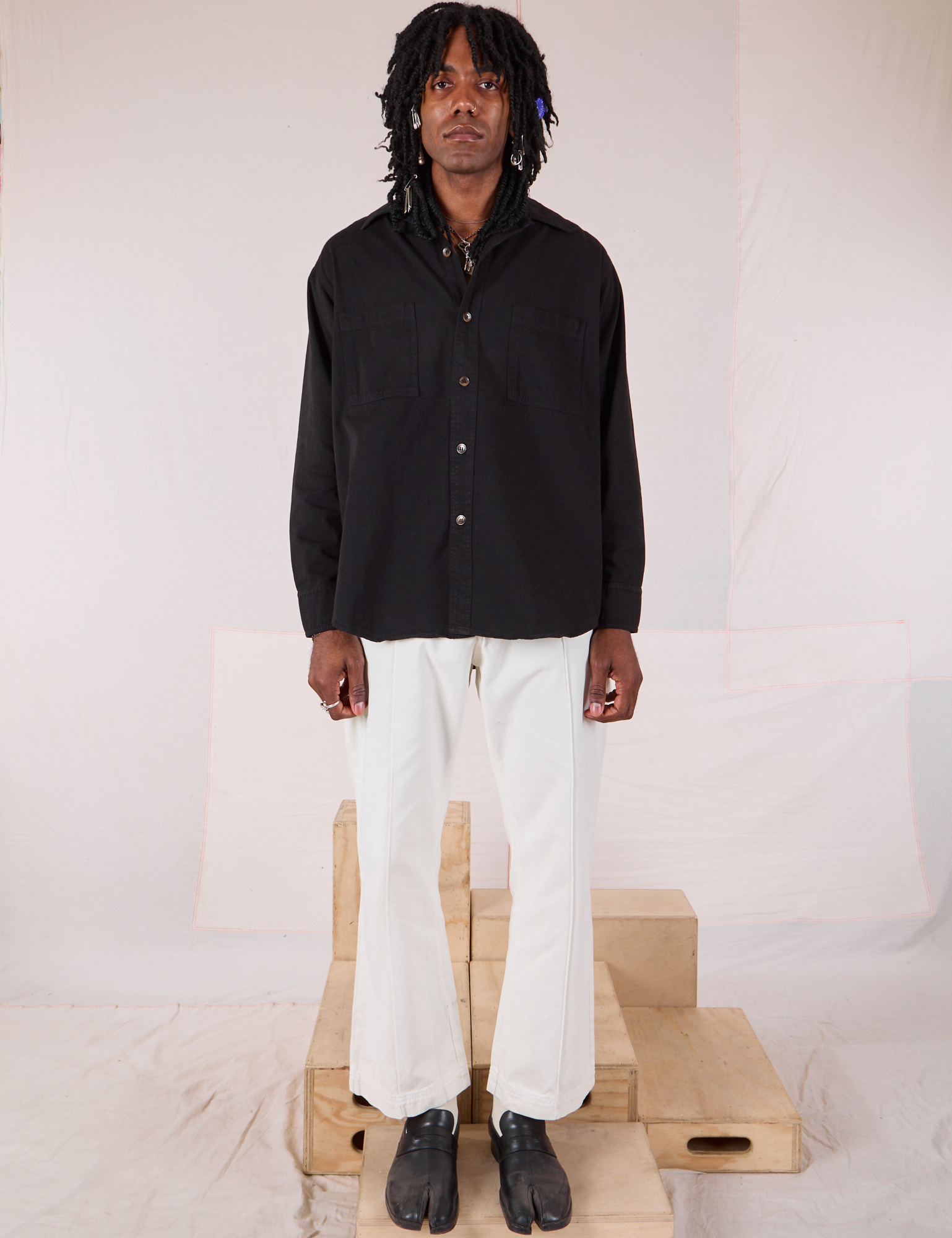 Jerrod is wearing a buttoned up Twill Overshirt in Basic Black with vintage tee off-white Western Pants